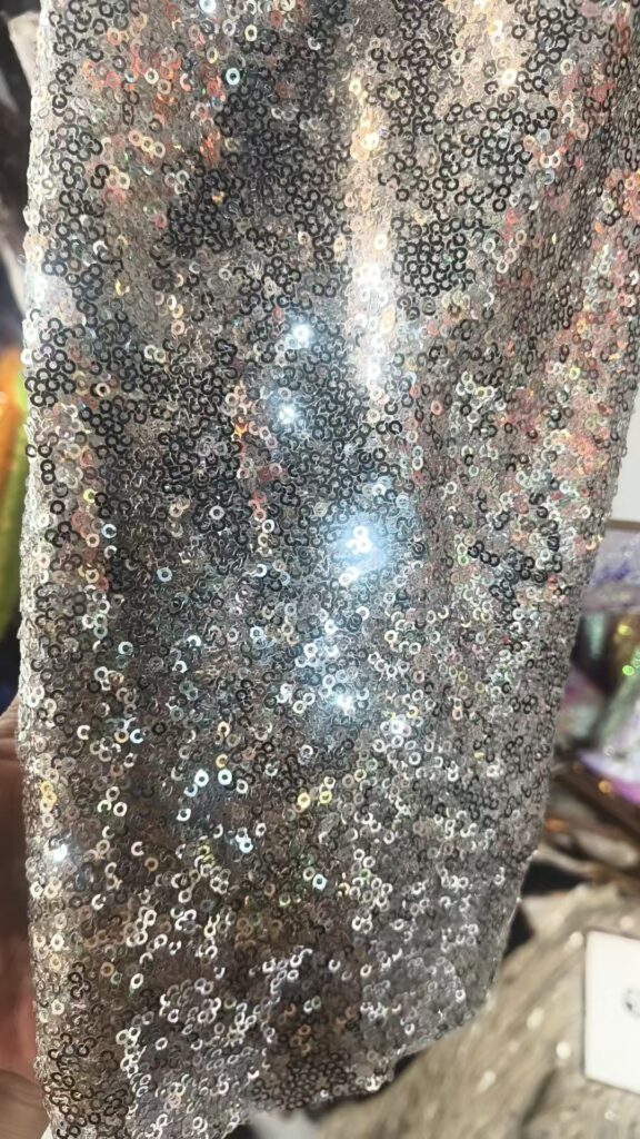 Close-up photograph of silver-tone sequin material reviewed for development