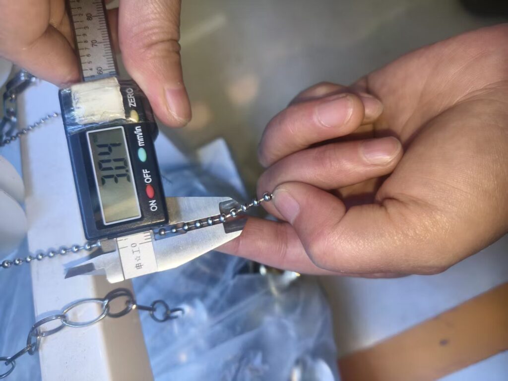 Ball-chain dimensions checked with a digital calliper during sourcing