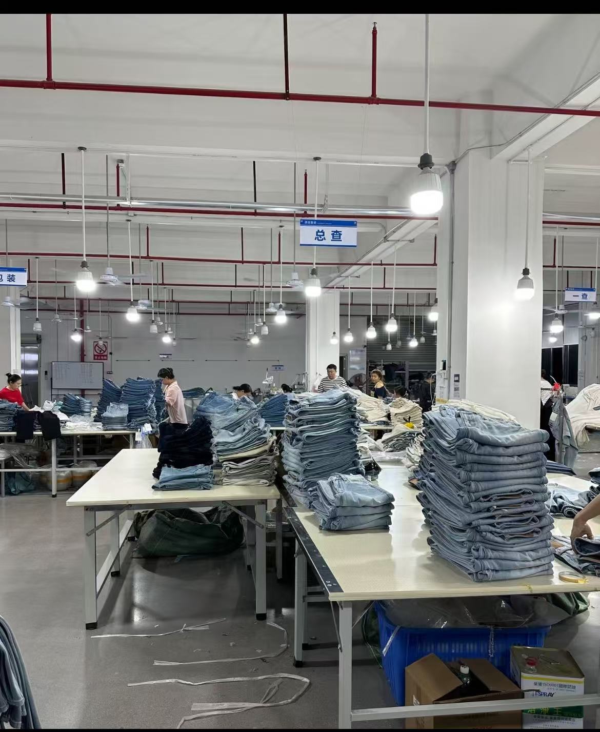 Denim final quality inspection area with finished jeans arranged for checking before approval